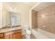 Bathroom features granite counters, oak vanity, tiled floors, and a shower-tub combo with tile surround at 4760 Wheel House Dr, New Port Richey, FL 34652