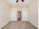 Bedroom with neutral carpet, paint, ceiling fan, and closets on both sides of doorway at 4760 Wheel House Dr, New Port Richey, FL 34652