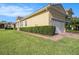View of the side and front of the home, showing the manicured lawn and tidy landscaping around the house at 4760 Wheel House Dr, New Port Richey, FL 34652