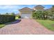 Charming home with a brick driveway, a two-car garage, and mature landscaping, adding curb appeal at 4760 Wheel House Dr, New Port Richey, FL 34652
