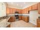 The kitchen has granite countertops, stainless steel appliances, and ample wood cabinetry for storage at 4760 Wheel House Dr, New Port Richey, FL 34652
