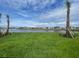 Expansive green lawn and serene lake view create a tranquil backyard setting with a waterfront view at 4947 Ribbon Rock Cv, Lakewood Ranch, FL 34211