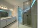 Modern bath with double vanity, sleek fixtures, and glass shower with tiled walls and rainfall shower head at 4947 Ribbon Rock Cv, Lakewood Ranch, FL 34211