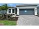 Beautiful one-story home featuring a two-car garage, stone driveway, green lawn and fresh, tropical landscaping at 4947 Ribbon Rock Cv, Lakewood Ranch, FL 34211