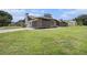Spacious home exterior featuring a side-entry garage, manicured landscaping, and a well-maintained lawn at 513 Sportsman Park Dr, Seffner, FL 33584