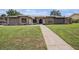 Inviting single-story home featuring a well-manicured lawn, brick accents, and a pathway leading to the front door at 513 Sportsman Park Dr, Seffner, FL 33584