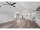 Open living room featuring wood floors, ceiling fan and an open view to the kitchen and screened-in pool area at 513 Sportsman Park Dr, Seffner, FL 33584