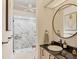 Bathroom featuring a black countertop, round mirror, and walk-in shower with marbled tile at 5217 88Th E St, Bradenton, FL 34211