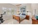 Cozy bedroom with shutters, ceiling fan, boat artwork, and ample natural light streaming in from large windows at 5217 88Th E St, Bradenton, FL 34211