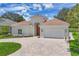 Front exterior with lush lawn, paver driveway, and attached two-car garage at 5217 88Th E St, Bradenton, FL 34211