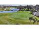 Breathtaking aerial view of golfers on a meticulously maintained golf course and serene blue lake at 5217 88Th E St, Bradenton, FL 34211