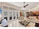 Bright living room with oversized windows, modern furniture, and an open floor plan to the kitchen at 5217 88Th E St, Bradenton, FL 34211
