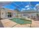 A private pool area features a sparkling pool, spa, and lounge chairs under a screened enclosure at 5217 88Th E St, Bradenton, FL 34211