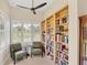 Sitting room with a large window, two green chairs, and bookshelves full of books at 5217 88Th E St, Bradenton, FL 34211
