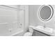 Modern bathroom features a shower-tub combo, circular mirror, and updated vanity at 6924 Americana Ne Dr # 167, St Petersburg, FL 33702
