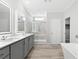 Modern bathroom boasts dual sinks, a glass shower, and a soaking tub at 6924 Americana Ne Dr # 167, St Petersburg, FL 33702