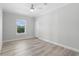 Bright bedroom with light wood floors, ceiling fan, window, and white trim at 6924 Americana Ne Dr # 167, St Petersburg, FL 33702