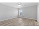 Bright bedroom with wood-look floors, ceiling fan, and window view at 6924 Americana Ne Dr # 167, St Petersburg, FL 33702