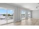 Bright living room with water view balconies and wood-look flooring, ceiling fan at 6924 Americana Ne Dr # 167, St Petersburg, FL 33702