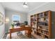 Home office with desk, bookcase, and a bright window at 6924 Americana Ne Dr # 167, St Petersburg, FL 33702