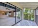 View of the living room through sliding glass doors leading to a tiled balcony with a view of the pool at 700 Starkey Rd # 1145, Largo, FL 33771