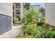 Exterior walkway shows lush tropical plants and flowers along the side of the building at 700 Starkey Rd # 1145, Largo, FL 33771