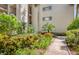 A walkway winds through vibrant landscaping surrounding the exterior of the condominium building at 700 Starkey Rd # 1145, Largo, FL 33771