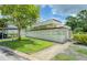 White condominium building featuring a lush lawn, mature tree, and convenient resident mailboxes at 700 Starkey Rd # 1145, Largo, FL 33771