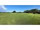 Rolling green golf course with a distant flag and lush trees, set against a clear blue sky at 700 Starkey Rd # 1145, Largo, FL 33771
