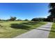Well-manicured golf course with a paved cart path under a clear blue sky at 700 Starkey Rd # 1145, Largo, FL 33771