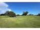 Scenic golf course view with mature trees and a small water feature on a sunny day at 700 Starkey Rd # 1145, Largo, FL 33771