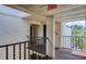 Hallway with black metal railing and exterior view of trees and sky from covered walkway at 700 Starkey Rd # 1145, Largo, FL 33771
