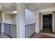 Hallway leading to a front door with a black metal railing and outdoor light fixture at 700 Starkey Rd # 1145, Largo, FL 33771