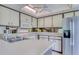 Bright kitchen featuring white cabinets, stainless steel refrigerator, and modern appliances at 700 Starkey Rd # 1145, Largo, FL 33771