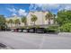 Covered parking area featuring assigned parking spots and lush palm trees at 700 Starkey Rd # 1145, Largo, FL 33771
