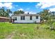 Backyard of cozy single-story home featuring lush green lawn and mature landscaping at 812 W Orient St, Tampa, FL 33603