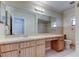 The bathroom features a large mirror, vanity with cabinets, toilet, and access to shower-tub area at 8200 Westfield Dr, Port Richey, FL 34668