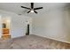 Bright bedroom features neutral carpeting, ceiling fan, a closet, and a doorway to the ensuite bathroom at 8200 Westfield Dr, Port Richey, FL 34668
