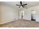 Bright bedroom features neutral carpeting, ceiling fan, a closet, and a doorway at 8200 Westfield Dr, Port Richey, FL 34668