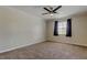 Bright bedroom features neutral carpeting, ceiling fan, and a window with curtains for a cozy space at 8200 Westfield Dr, Port Richey, FL 34668