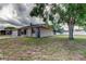 Side view of the residence showcasing the manicured lawn and the home's architectural style and white fenced back yard at 8200 Westfield Dr, Port Richey, FL 34668