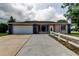 Charming single-story home featuring a spacious driveway and a well-maintained lawn with a white fence at 8200 Westfield Dr, Port Richey, FL 34668