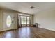 Bright living room with wood-look tile flooring, a large bay window, and a stylish front door at 8200 Westfield Dr, Port Richey, FL 34668