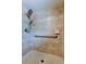 Tiled walk-in shower featuring updated shower head, grab bar, and built-in soap dish at 8200 Westfield Dr, Port Richey, FL 34668