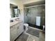 Modern bathroom features a frameless shower, granite countertop vanity, and contemporary fixtures at 8616 Pinafore Dr, New Port Richey, FL 34653