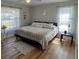 Cozy bedroom featuring natural light, a queen bed, wood floors, and a neutral color scheme at 8616 Pinafore Dr, New Port Richey, FL 34653