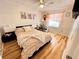 Bright bedroom with ceiling fan, wood floors, and a queen-sized bed covered with floral bedding at 8616 Pinafore Dr, New Port Richey, FL 34653