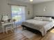 Bright bedroom with a comfortable bed, vanity, and large window at 8616 Pinafore Dr, New Port Richey, FL 34653