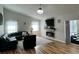 Cozy living room with a fireplace, hardwood floors, and large windows providing natural light at 8616 Pinafore Dr, New Port Richey, FL 34653