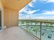 An expansive balcony with glass railings overlooking a parking lot and distant scenery at 880 Mandalay Ave # C512, Clearwater Beach, FL 33767
